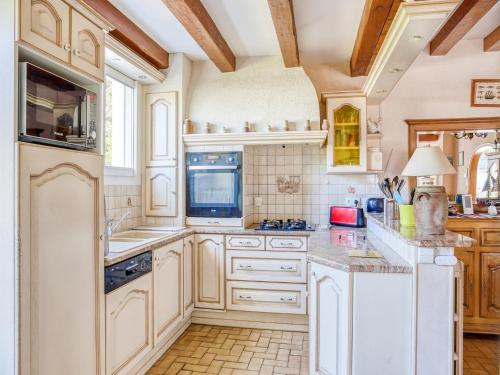 une cuisine avec des appareils électroménagers blancs et des armoires en bois dans l'établissement Beachside Family Retreat, à Pénestin