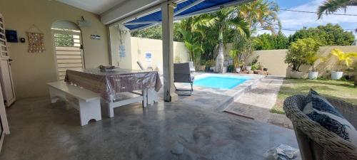 a patio with a table and a swimming pool at Villla NOULAKAZ in Port Mathurin