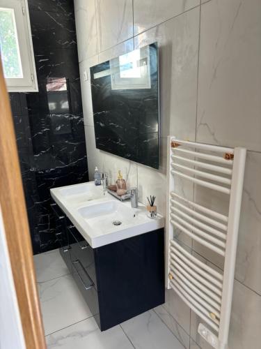 a bathroom with a sink and a mirror at Appartement avec 2 chambres proche Orly in Saint-Michel-sur-Orge