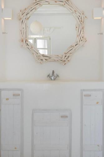 a wreath mirror on a wall above two white doors at Mando Pool Villas w Sea Views - Five Bedrooms in Super Paradise Beach