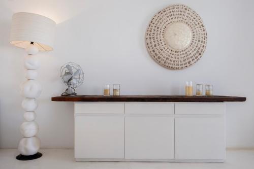 a white kitchen with a shelf and a mirror at Mando Pool Villas w Sea Views - Five Bedrooms in Super Paradise Beach