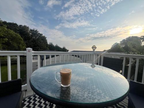 ビデフォードにあるKieras View At Bideford Bayのバルコニーのガラスのテーブルに置かれたコーヒーカップ