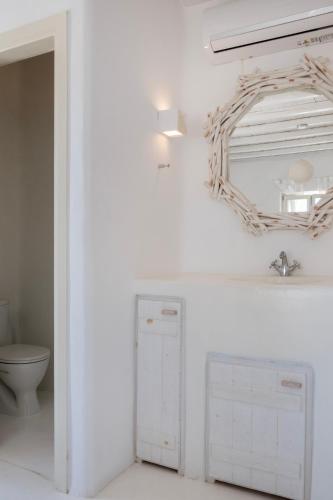 a bathroom with a mirror and a toilet at Mando Pool Villas w Sea Views - Five Bedrooms in Super Paradise Beach