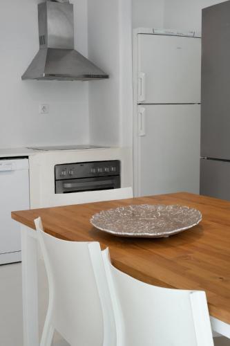 a kitchen with a wooden table and white appliances at Mando Pool Villas w Sea Views - Five Bedrooms in Super Paradise Beach