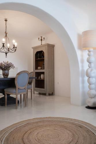 a dining room with a table and a chair at Mando Pool Villas w Sea Views - Five Bedrooms in Super Paradise Beach