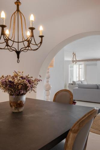 a dining room with a table with a vase of flowers at Mando Pool Villas w Sea Views - Five Bedrooms in Super Paradise Beach