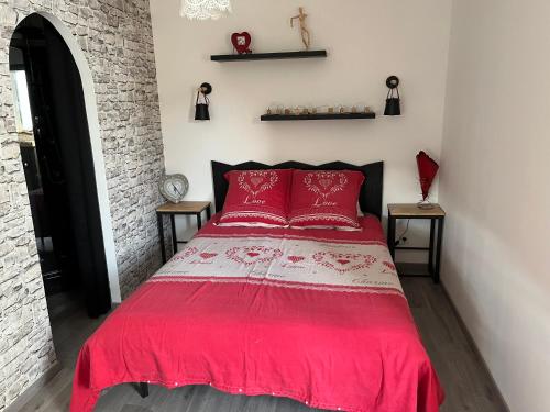 een rood bed met rode kussens in een slaapkamer bij Jura Nature in Saint-Claude