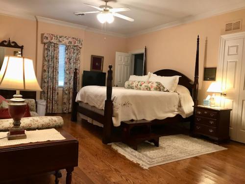 a bedroom with a bed and a table with a lamp at Virginia Cliffe Inn in Glen Allen
