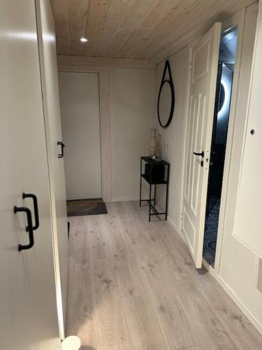 an empty room with a hallway with a door and a table at Casa de Taira in Sandefjord