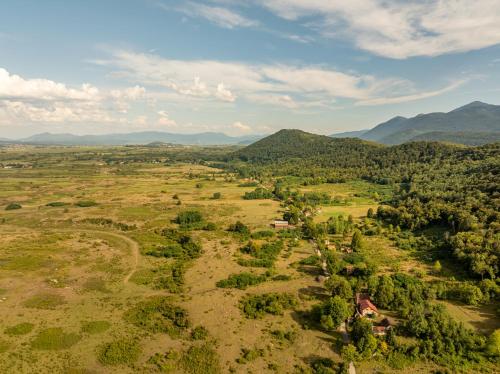 an aerial view of a field with mountains in the background at Forest Paradise in Ličko Petrovo Selo