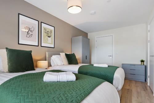 two beds in a bedroom with green and white at Richmond Apartments - Air Host & Stay in Liverpool