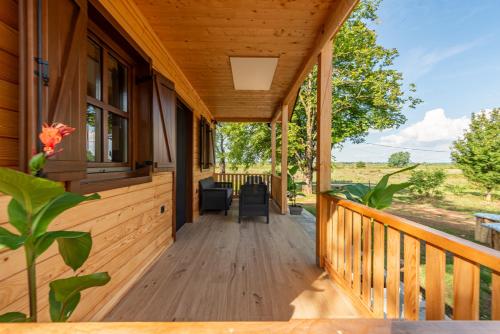 a porch of a wooden house with a view at Forest Paradise in Ličko Petrovo Selo