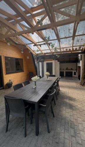 a large wooden table and chairs in a patio at Cabana A Vaideeni in Vaideeni