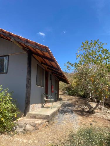 a house with a bench sitting outside of it at Catavento Pousada in Alto Paraíso de Goiás