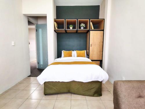 een slaapkamer met een groot bed met oranje kussens bij CASA NIAGARA in Mexico-Stad