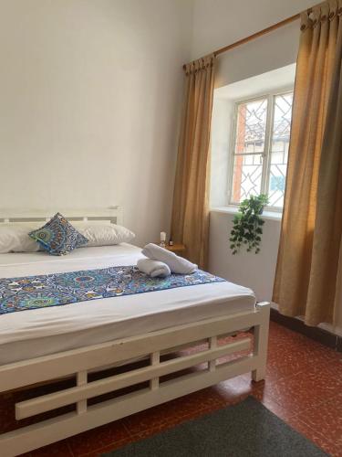 a bedroom with a large bed with a window at ADVENTURE Hostel in San Gil
