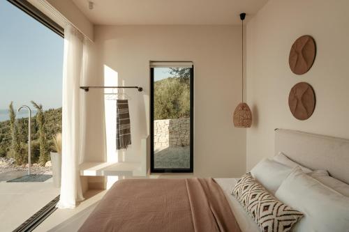 una camera da letto con un letto e una grande finestra di Noùs Corfu Villa a Kalámi