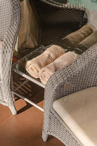 a glass shelf with towels on it next to a chair at AWARA POUSADA BOUTIQUE in São Miguel do Gostoso