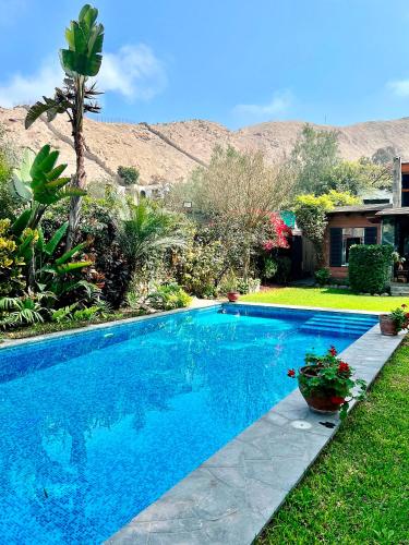 a blue swimming pool in a yard with a house at Casa Shanti in Cieneguilla