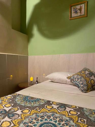 a bedroom with a bed and a green wall at ADVENTURE Hostel in San Gil