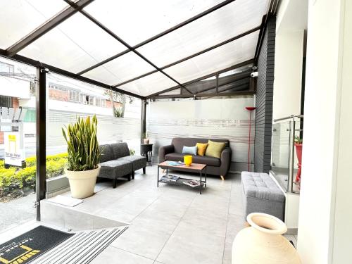 eine Terrasse mit Sofa, Stühlen und einem Tisch in der Unterkunft Terraza Hotel Bogota in Bogotá