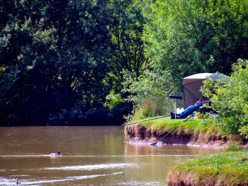 a person sitting in a tent in the middle of a river at Willow Plus 6 Hot Tub in Garton