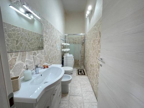 Un baño blanco con lavabo e inodoro. en Dolce Casa Salentina, en San Pietro in Bevagna