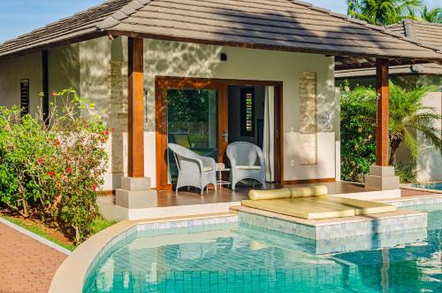 a house with a swimming pool in front of a house at AWARA POUSADA BOUTIQUE in São Miguel do Gostoso