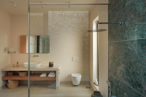 un bagno con doccia, lavandino e WC di Noùs Corfu Villa a Kalámi