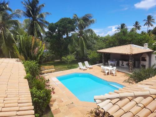 Una piscina en un patio trasero con un cenador. en Casa Lyrio - Itacimirim, en Camassari
