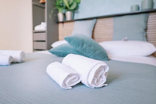 a bed with towels and pillows on it at Mennuli e mari - sicily home in Brucoli