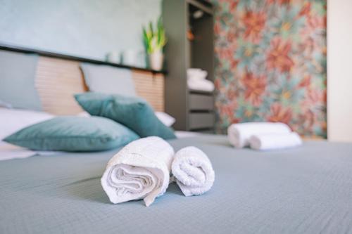 a pair of towels sitting on top of a bed at Mennuli e mari - sicily home in Brucoli