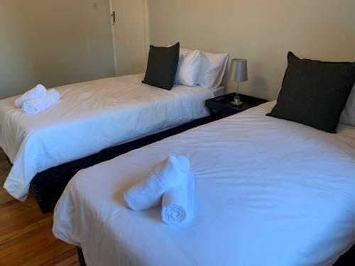 two beds with towels on them in a room at Palm Haven on Sarnia in Durban