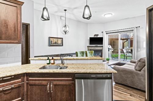 a kitchen with a sink and a living room at Mountain Getaway in Canmore - Sleeps 6 - Pool & Hottub in Canmore