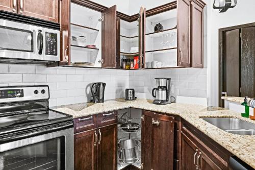 a kitchen with wooden cabinets and a counter top at Mountain Getaway in Canmore - Sleeps 6 - Pool & Hottub in Canmore