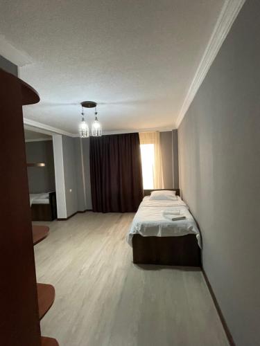 a bedroom with a bed in the middle of a room at Hotel Kavkasioni in Kvareli
