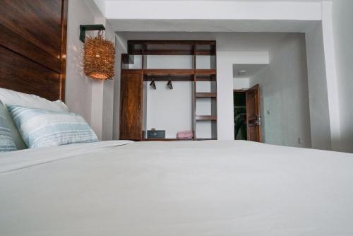 a bedroom with a large white bed and a mirror at The Mint Resort Isla Mujeres in Isla Mujeres