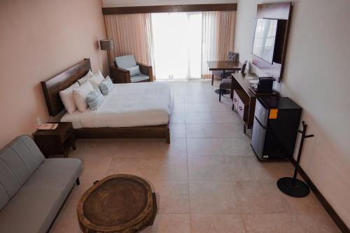 a hotel room with a bed and a couch at The Mint Resort Isla Mujeres in Isla Mujeres