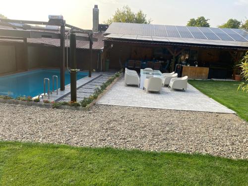 Eftimie MurguにあるPensiunea Danieliの白いテーブルと椅子付きのパティオ(建物の隣)