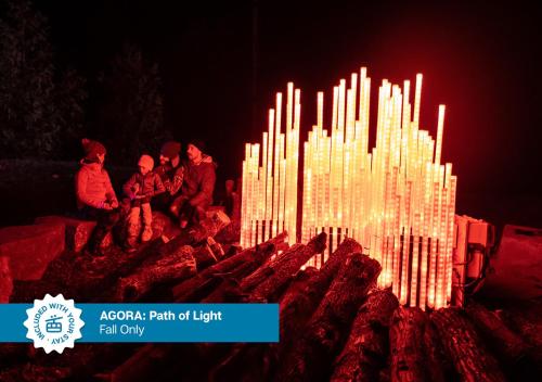 a group of people sitting around a large lit up fire at The Westin Trillium House, Blue Mountain in Blue Mountains