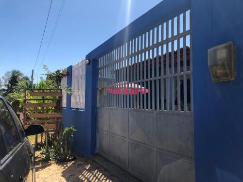 a blue wall with a gate on it at Casa Beija Flor - Baleia Beach in Itapipoca