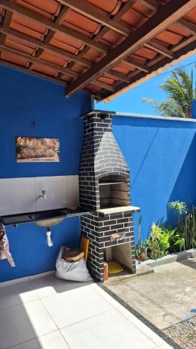 a brick oven in a patio with a blue wall at Casa Beija Flor - Baleia Beach in Itapipoca