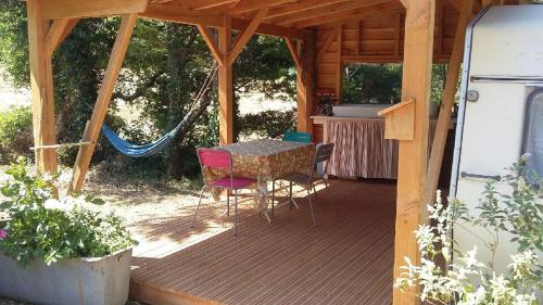 a porch of a cabin with a table and chairs at Ô Grézac in Lodève