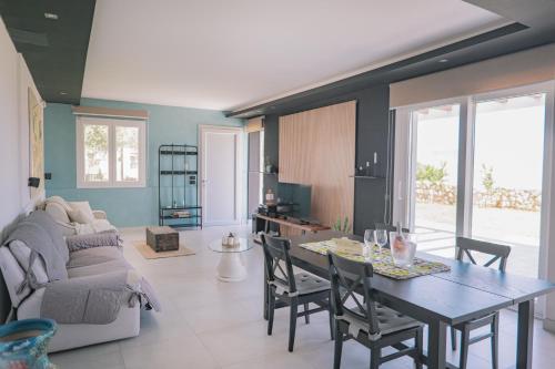 a living room with a table and chairs and a couch at Mennuli e mari - sicily home in Brucoli