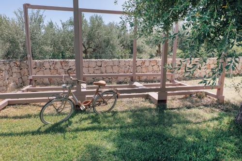 a bike parked in the grass next to a bench at Mennuli e mari - sicily home in Brucoli