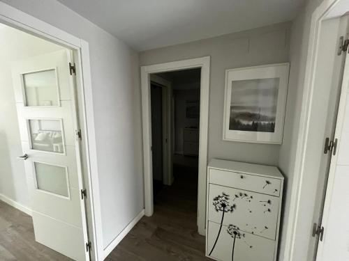 a hallway with a door and a dresser in a room at Los Alamos Breeze - Modern Beach Apartment in Torremolinos