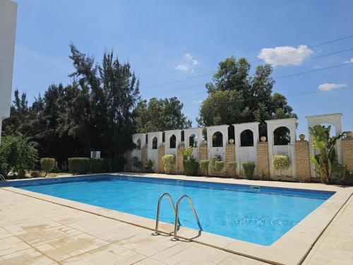 a swimming pool in front of a house at Chic Apartment Near the Sea in Yasmine