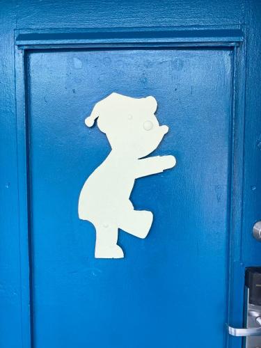 a white sign on the side of a blue door at Gainesville Lodge in Gainesville