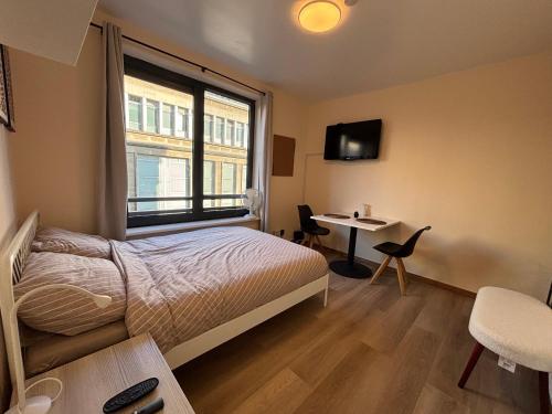 Un dormitorio con una cama y un escritorio y una ventana. en BXL cozy appartment, en Bruselas