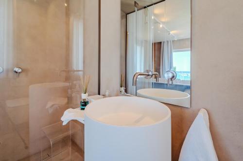 a white bathroom with a sink and a mirror at Hybrid Icon Rooms Gallery in Palermo
